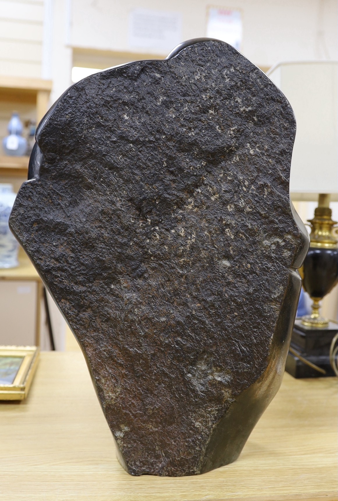 A Zimbabwean carved and polished stone abstract study of a crouching figure, 55cms.